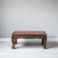 Opiumtisch mit goldfarbener Verzierung und roter Tischplatte